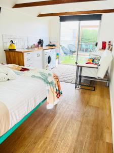 a bedroom with a bed and a kitchen with a patio at Tiny Tom - Hidden beside the river Mersey in Devonport