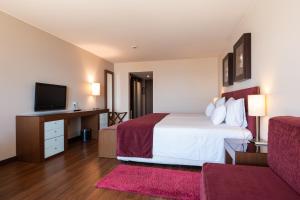 a hotel room with a bed and a flat screen tv at Vila Gale Cascais in Cascais