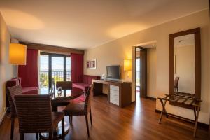 a living room with a dining table and a television at Vila Gale Cascais in Cascais