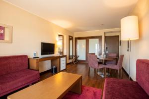 a living room with a red couch and a television at Vila Gale Cascais in Cascais