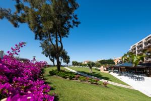 a park with pink flowers and a building at Vila Gale Cascais in Cascais