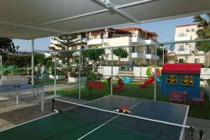 a play area with a ping pong table and playground at Philoxenia Hotel & SPA in Malia