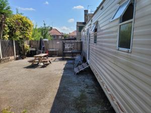 a side of a house with a picnic table next to it at The Jackdaw B&B SELF CATERING STATIC CARAVAN FREE BREAKFAST SUPPLIED in Tadcaster