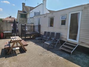 a patio with chairs and a table and a house at The Jackdaw B&B SELF CATERING STATIC CARAVAN FREE BREAKFAST SUPPLIED in Tadcaster