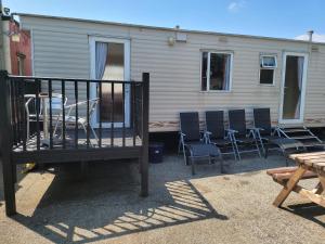 a group of chairs and a table and a house at The Jackdaw B&B SELF CATERING STATIC CARAVAN FREE BREAKFAST SUPPLIED in Tadcaster