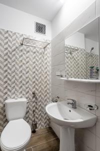 La salle de bains blanche est pourvue de toilettes et d'un lavabo. dans l'établissement Hotel Neko, à Saturn