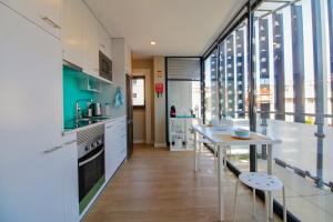 a kitchen with a table and a large window at Casa São Vicente - Apartment Near City Centre with Private Parking in Viana do Castelo