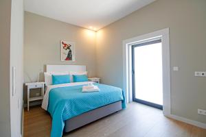 - une chambre avec un lit et une couverture bleue dans l'établissement Casa São Vicente - Apartment Near City Centre with Private Parking, à Viana do Castelo