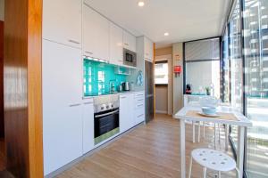 a kitchen with white cabinets and a table and a window at Casa São Vicente - Apartment Near City Centre with Private Parking in Viana do Castelo +14 photos