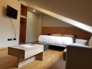 sypialnia z łóżkiem, kanapą i stołem w obiekcie Apartamentos Turísticos y Habitaciones Cidade Vella by Bossh! Hotels w mieście Ourense