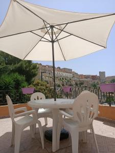 a white table and chairs with an umbrella at Casa dei Talenti in Cagliari