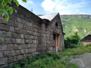 un viejo edificio de ladrillo con una puerta en una colina en Tumanyan Bathhouse Hostel, en Tʼumanyan