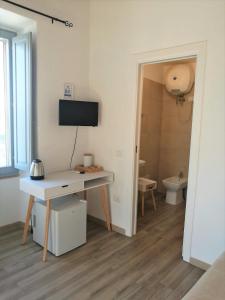 a room with a desk and a television and a bathroom at Casa dei Talenti in Cagliari