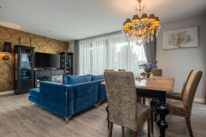 a dining room with a blue couch and a table at Vila „Neptūnas“ in Palanga