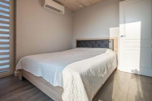 a bedroom with a bed with a white bedspread at Vila „Neptūnas“ in Palanga