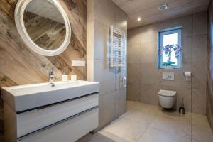 a bathroom with a white sink and a mirror at Vila „Neptūnas“ in Palanga +15 photos