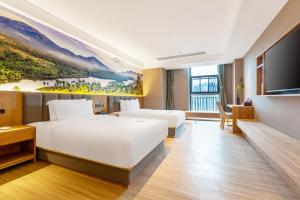 a hotel room with a large bed and a flat screen tv at TRUE Go hotel in Chengdu