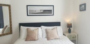 a bedroom with a bed with pillows and a mirror at Stylish 2 bed 2 bathroom apartment for up to 5 in Warwick