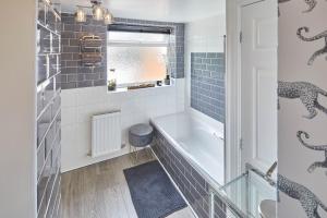 bagno con vasca e finestra di Host & Stay - Apartment 2, 15 Prospect Hill a Whitby
