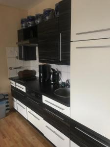 a kitchen with black and white cabinets and a sink at Ferienwohnung Rogi in Bad Wildungen