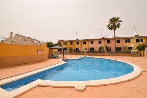 a large swimming pool in a courtyard with a building at Casa Robes Sa Pobla 170 by Mallorca Charme in Sa Pobla