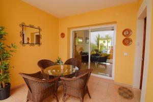 a dining room with a glass table and wicker chairs at Casa Robes Sa Pobla 170 by Mallorca Charme in Sa Pobla