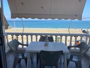 una mesa en un balcón con vistas a la playa en Tsatsoni - Anastasiou Studios, en Velika