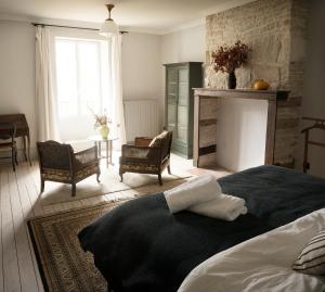 ein Schlafzimmer mit einem Bett mit zwei Handtüchern darauf in der Unterkunft The Riverhouse, magical house with garden by the river Seine in Gyé-sur-Seine + 6 Fotos