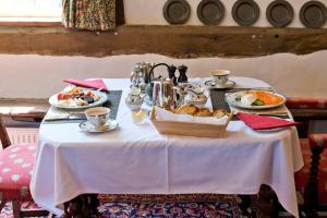 een tafel met een witte tafeldoek met voedsel erop bij Lower Wythall B&B in Ross on Wye