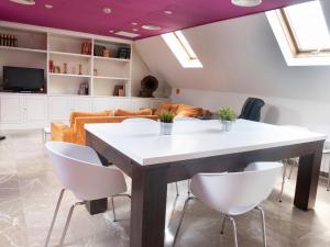 uma sala de estar com uma mesa e cadeiras brancas em Aparthotel G3 Galeon em Madrid