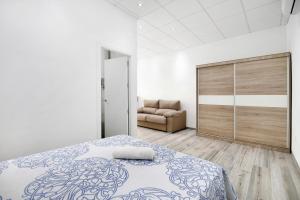 biała sypialnia z łóżkiem i kanapą w obiekcie Apartamento Venus 1 w mieście Conil de la Frontera