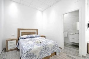 biała sypialnia z łóżkiem i łazienką w obiekcie Apartamento Venus 1 w mieście Conil de la Frontera