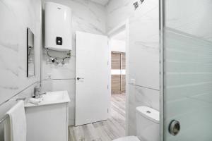 biała łazienka z prysznicem i toaletą w obiekcie Apartamento Venus 1 w mieście Conil de la Frontera