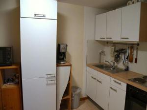 a kitchen with a white refrigerator and a sink at Ferienwohnung am Berg in Rickenbach