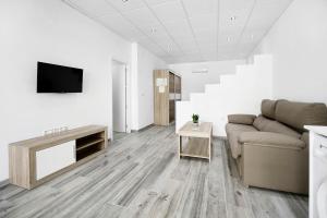 a living room with a couch and a tv at Apartamento Venus 3 in Conil de la Frontera