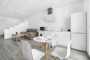 a white kitchen with a white table and chairs at Apartamento Venus 3 in Conil de la Frontera