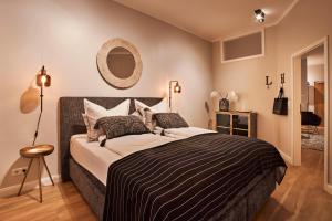 a bedroom with a large bed and a mirror at Dalberg Loft - Boutique Ferienwohnung im Zentrum in Fulda +8 photos