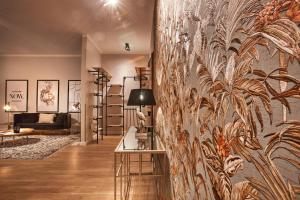 a living room with a wall with a mural of plants at Dalberg Loft - Boutique Ferienwohnung im Zentrum in Fulda