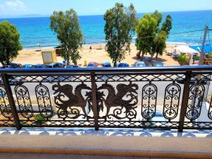 a balcony with a view of a beach and the ocean at Aphrodite's Apartments in Artemida
