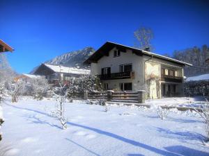 een huis met sneeuw op de grond ervoor bij Ferienwohnungen Schmidt in Berchtesgaden