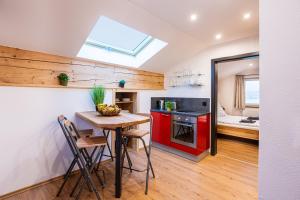 a kitchen with red cabinets and a table with chairs at Ferienwohnungen Schmidt in Berchtesgaden