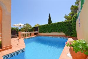een zwembad in een tuin met planten bij Villa Posidonia 050 by Mallorca Charme in Son Serra de Marina