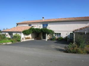 a large white house with a driveway in front of it at Les Bienfaits d'Harmonium in La Chapelle-Gaudin