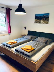 a bedroom with a large wooden bed with orange pillows at Pernerhof in Mariapfarr