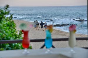 eine Gruppe von Menschen, die am Strand spazieren in der Unterkunft Pumula Beach Hotel in Umzumbe