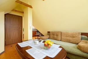 a living room with a table with a bowl of fruit on it at Apartment Wojciecha Brzegi Zakopane by Renters in Zakopane