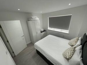 a small bedroom with a bed and a television at London Dagenham Apartments in Dagenham