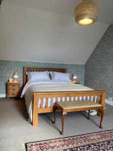 a bedroom with a large bed and a bench at Arran School House - Blackwaterfoot, Isle of Arran in Blackwaterfoot