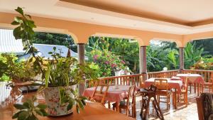 a restaurant with tables and chairs on a deck at Bernique Guesthouse in La Digue
