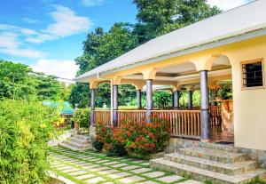 a house with a porch with stairs and flowers at Bernique Guesthouse in La Digue
